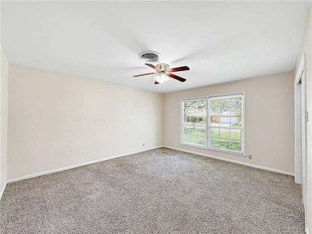 empty room with carpet, visible vents, baseboards, and ceiling fan