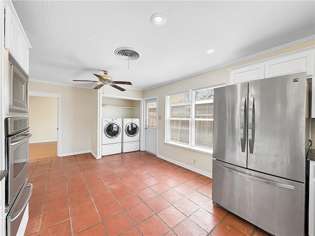 kitchen featuring ceiling fan, visible vents, a warming drawer, appliances with stainless steel finishes, and washing machine and dryer