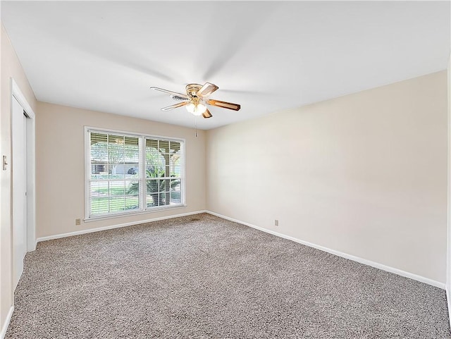 empty room featuring carpet flooring, baseboards, and a ceiling fan