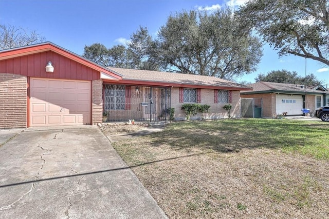 ranch-style home with a front lawn, a garage, brick siding, and driveway