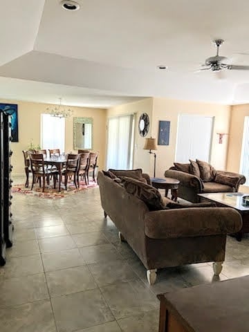 living room with ceiling fan with notable chandelier