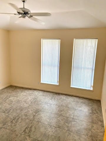 spare room with a wealth of natural light and ceiling fan