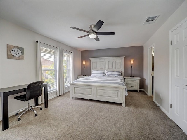 bedroom featuring light carpet, ceiling fan, an office area, and baseboards
