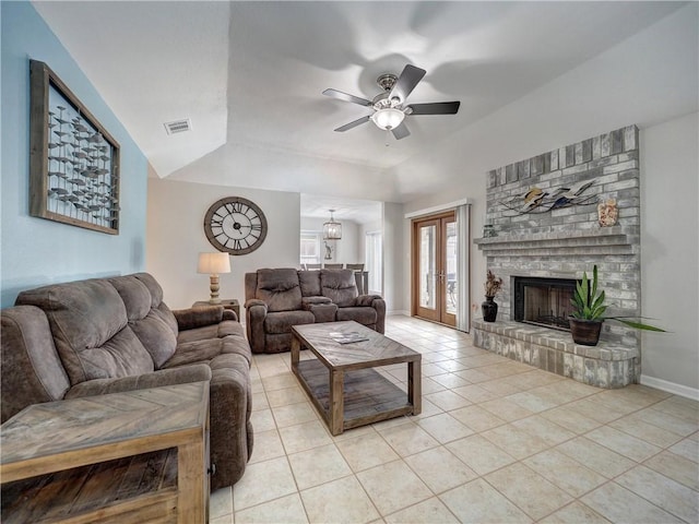 living room with ceiling fan, light tile patterned floors, a brick fireplace, baseboards, and a raised ceiling