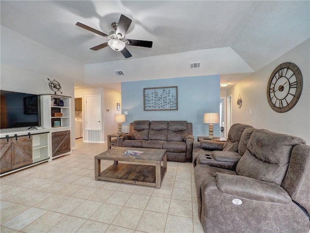 living room with light tile patterned flooring, a raised ceiling, a ceiling fan, and built in shelves