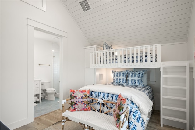 bedroom with vaulted ceiling, wood finished floors, wood ceiling, ensuite bath, and visible vents