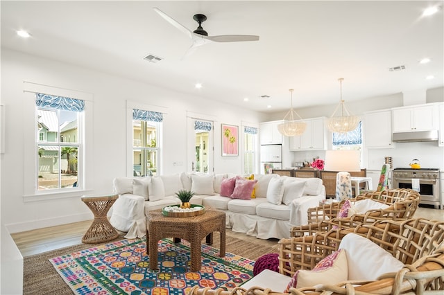 living room with light wood-type flooring, baseboards, visible vents, recessed lighting, and a ceiling fan
