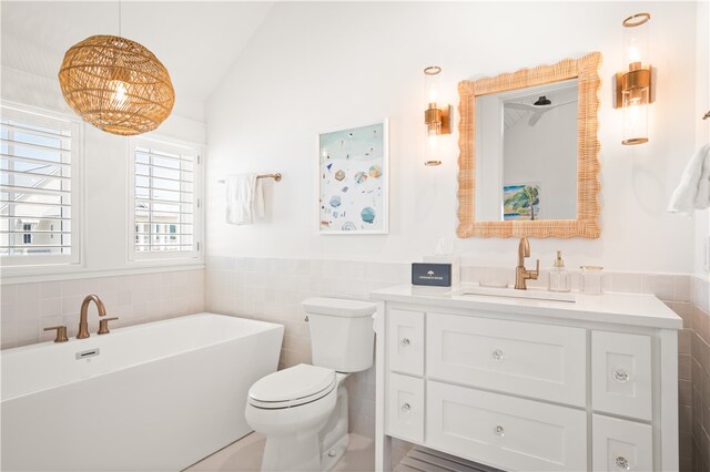 full bath featuring tile walls, vaulted ceiling, a freestanding tub, and toilet