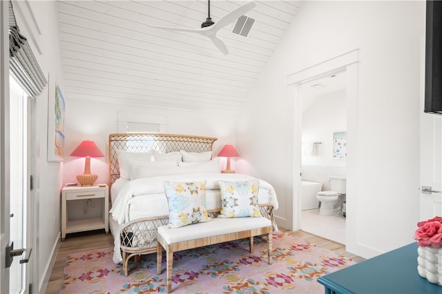 bedroom featuring lofted ceiling, wooden ceiling, wood finished floors, and connected bathroom
