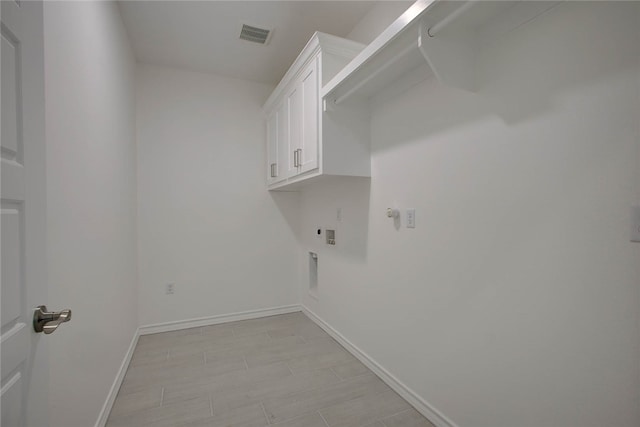 clothes washing area with hookup for an electric dryer, washer hookup, cabinets, and hookup for a gas dryer