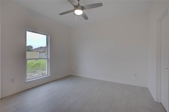 spare room with ceiling fan and light wood-type flooring