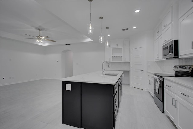 kitchen with a center island with sink, sink, white cabinetry, and appliances with stainless steel finishes