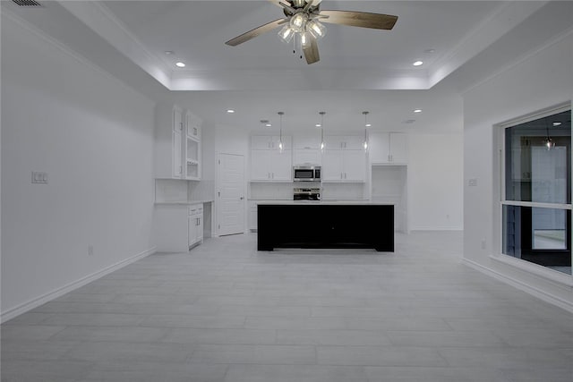 kitchen with white cabinetry, stainless steel appliances, ceiling fan, and a center island