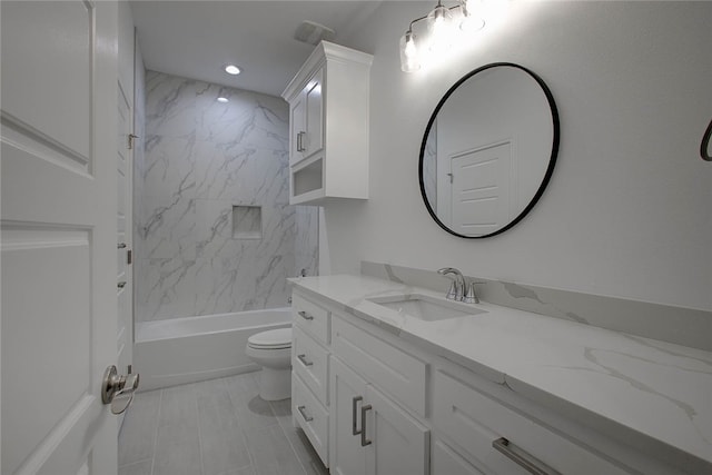 full bathroom with vanity, tiled shower / bath combo, and toilet