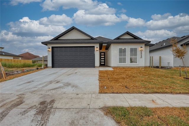 view of front of property with a garage and a front lawn