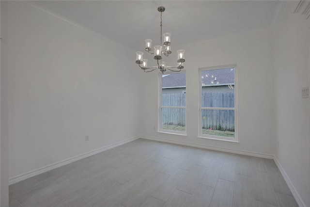 spare room with light wood-type flooring, a chandelier, and crown molding