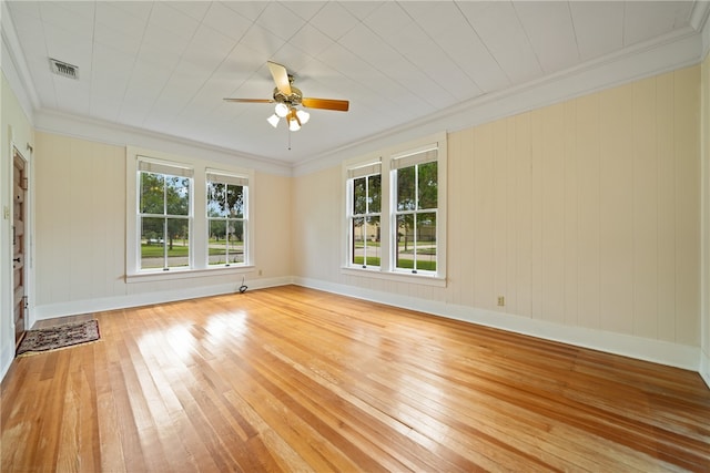 unfurnished room featuring ornamental molding, light wood-type flooring, and a healthy amount of sunlight