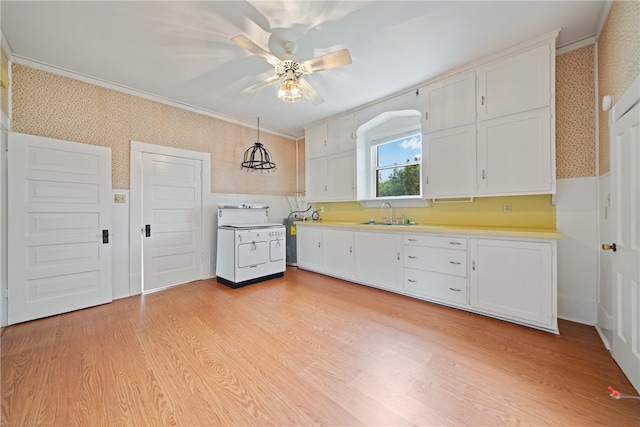 kitchen featuring white cabinets, light wood-type flooring, and hanging light fixtures