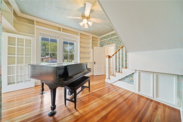 miscellaneous room with light hardwood / wood-style floors, ceiling fan, and lofted ceiling