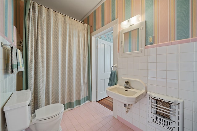 bathroom with tile walls, tile patterned flooring, sink, and toilet