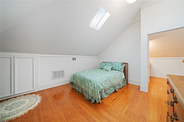 bedroom with light wood-type flooring and vaulted ceiling with skylight