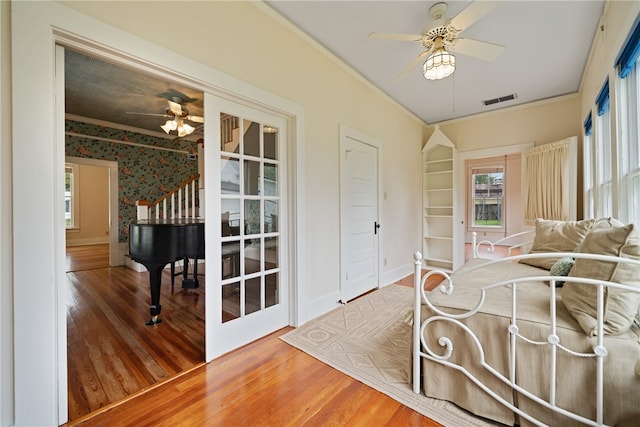 bedroom featuring ornamental molding, hardwood / wood-style flooring, and ceiling fan