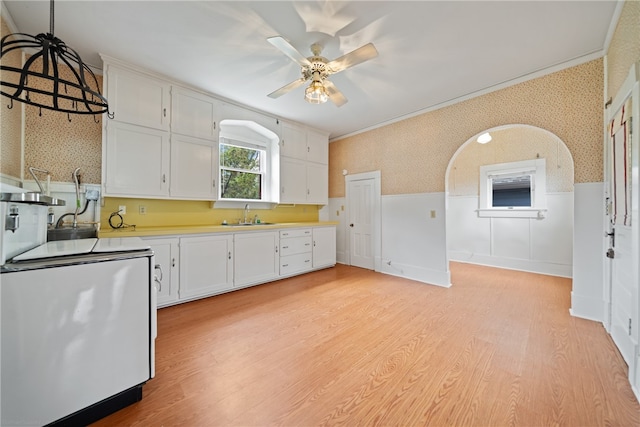 kitchen with light hardwood / wood-style floors, sink, ceiling fan, white cabinets, and pendant lighting