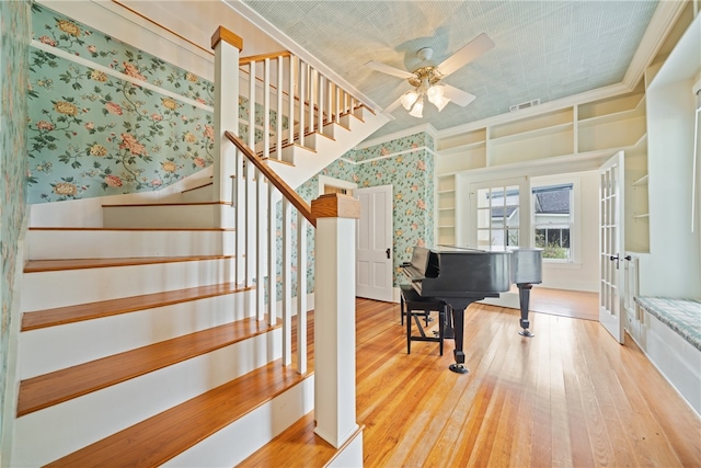 entrance foyer with ornamental molding, ceiling fan, and light hardwood / wood-style floors