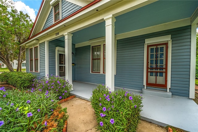 view of exterior entry featuring covered porch