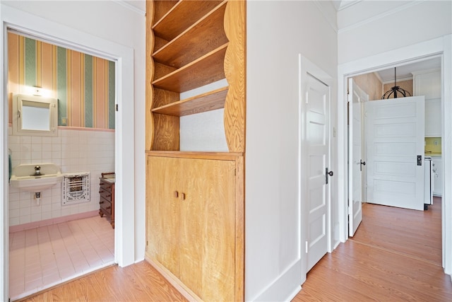 hall with tile walls, sink, and hardwood / wood-style flooring