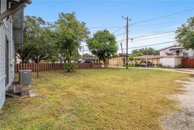 view of yard with a carport and central AC unit