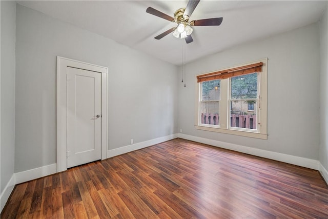 unfurnished room with ceiling fan and dark wood-type flooring