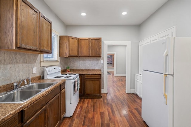 kitchen featuring white appliances, dark hardwood / wood-style floors, tasteful backsplash, and sink