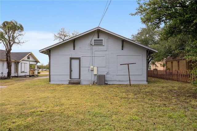 rear view of house featuring a yard and central air condition unit