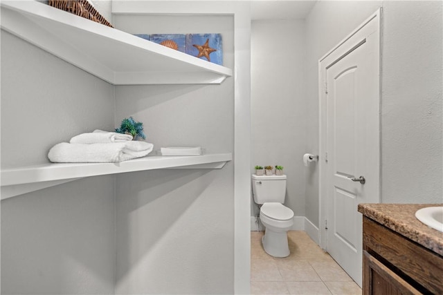 bathroom featuring toilet, vanity, and tile patterned flooring