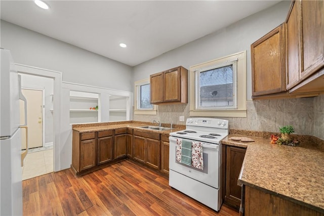 kitchen featuring sink, white appliances, tasteful backsplash, and dark hardwood / wood-style floors