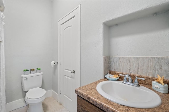 bathroom with tile patterned flooring, vanity, and toilet