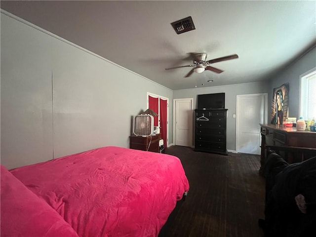 bedroom featuring wood finished floors, visible vents, baseboards, and ceiling fan