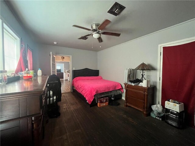 bedroom with wood finished floors, visible vents, and ceiling fan
