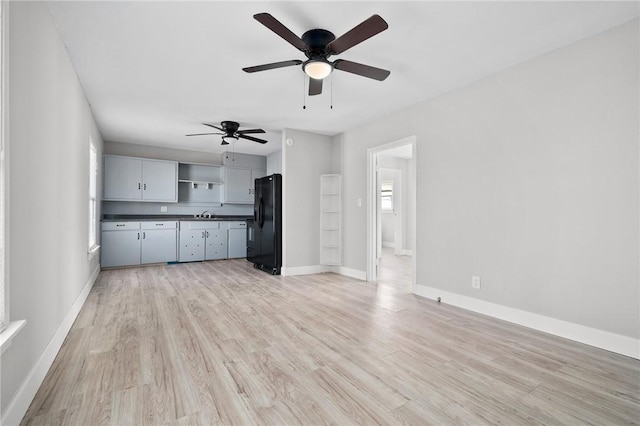 unfurnished living room featuring ceiling fan and light hardwood / wood-style floors