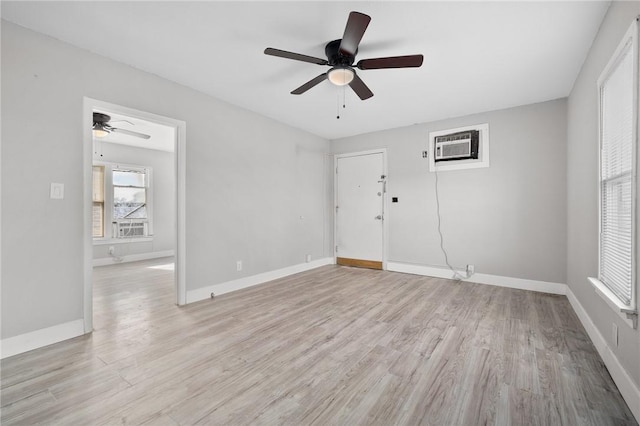 unfurnished room featuring light hardwood / wood-style floors, an AC wall unit, and ceiling fan