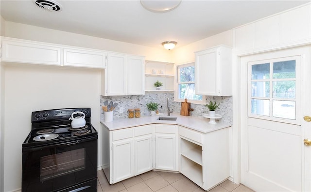 kitchen with black range with electric stovetop, sink, white cabinets, and light tile patterned flooring