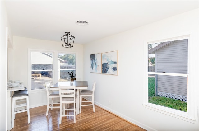 dining room with hardwood / wood-style floors and a notable chandelier