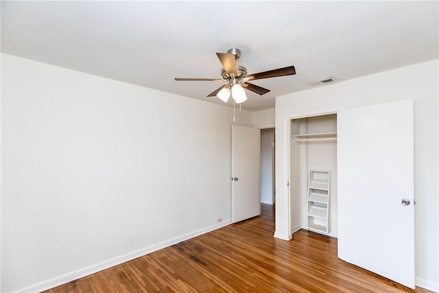 unfurnished bedroom with hardwood / wood-style flooring, ceiling fan, and a closet