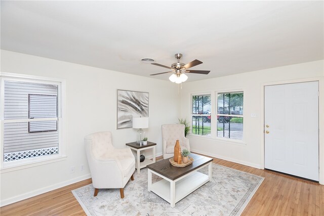 living area with ceiling fan and light hardwood / wood-style floors