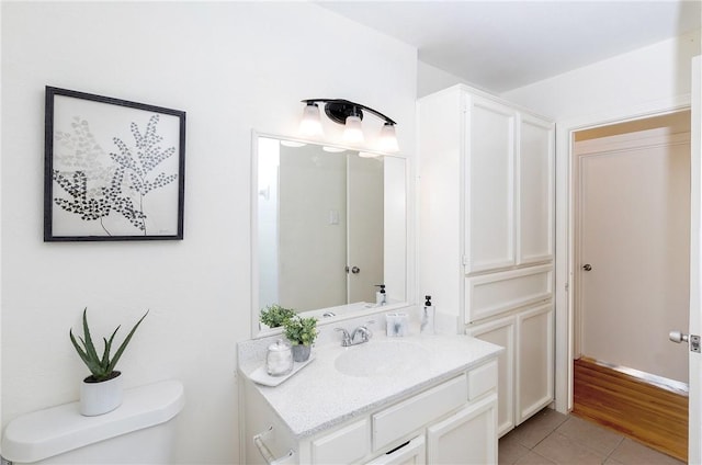 bathroom with toilet, vanity, and tile patterned floors