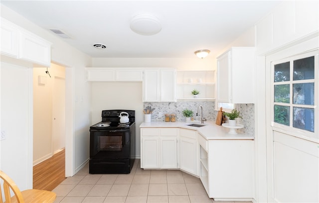 kitchen featuring light tile patterned flooring, white cabinetry, black / electric stove, and sink