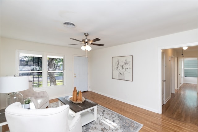 living room featuring wood-type flooring and ceiling fan