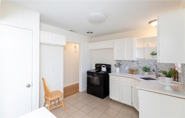 kitchen featuring white cabinetry, sink, black range with electric cooktop, tasteful backsplash, and light tile patterned floors