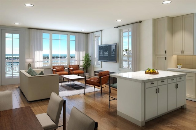 kitchen with recessed lighting, light wood-type flooring, a kitchen island, and decorative backsplash